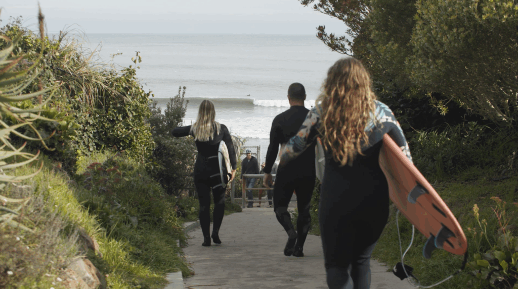 Community members carrying surfboards walking to beach in Santa Cruz. Could fit both MCCTS or People