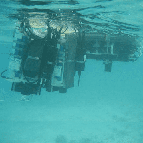 OPTICS remedy design tool deployed underwater showing sensors and monitoring equipment beneath water surface.